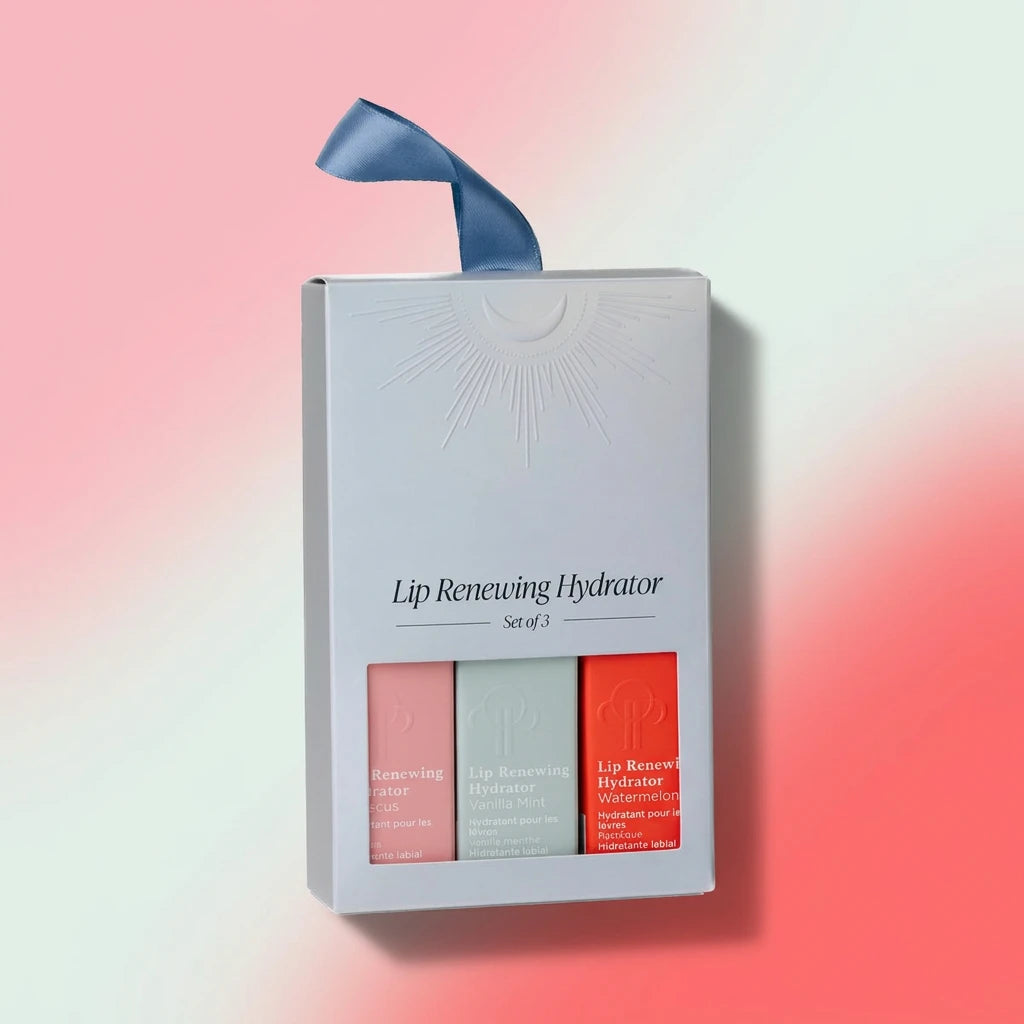 Lip Renewing Hydrator Set of 3 gift box, featuring three lip balm sticks in pink, sage green, and coral red, with a blue ribbon on a white background.