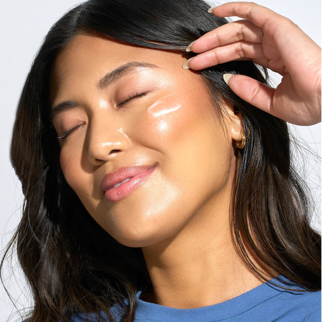 Woman applying GlowTone to her face with a hand
