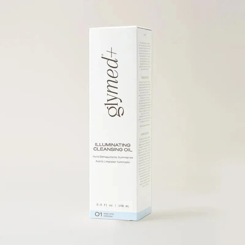 A tall white rectangular box of glymed+ Illuminating Cleansing Oil, shown standing upright on a light beige studio background. The box features black text and a small pale blue band at the bottom.