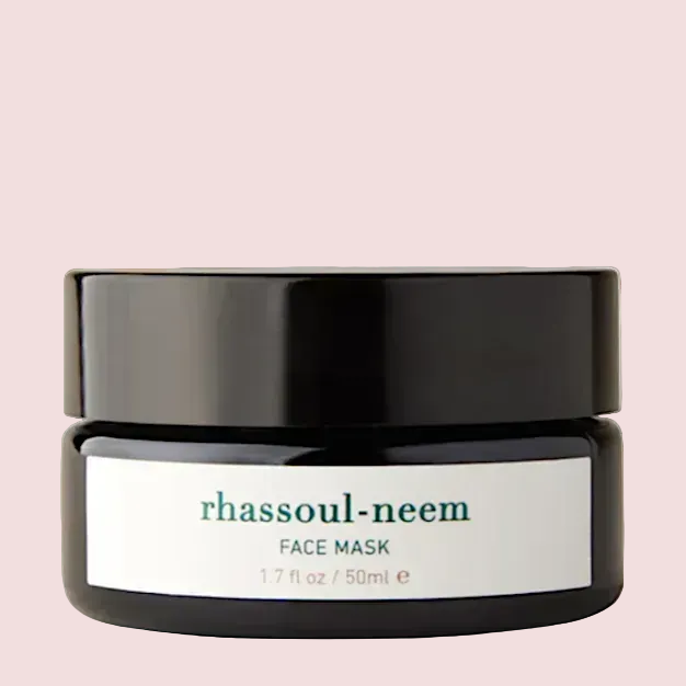 Black jar of rhassoul-neem face mask on a white background