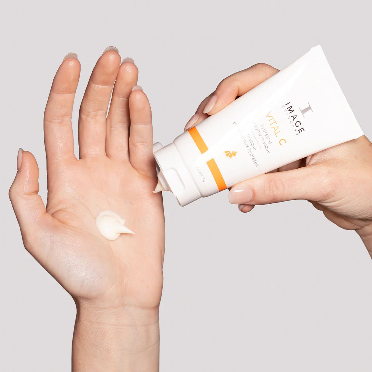 Person applying Image skincare VITAL C hydrating enzyme masque  to their hand with a gray background