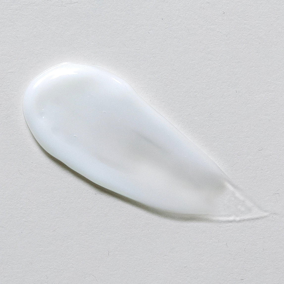 White cream or gel smear on a gray background