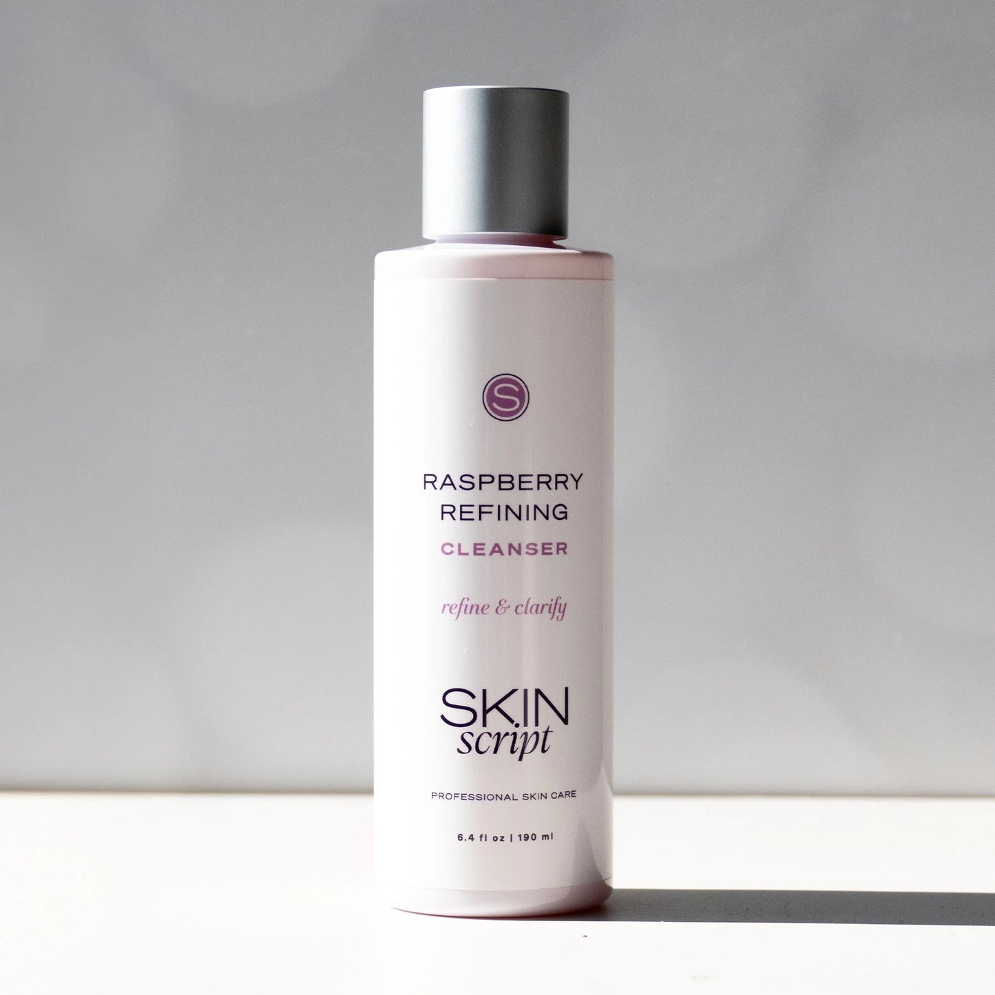 Skincare bottle labeled 'Raspberry Refining Cleanser' by 'Skin Script' on a neutral background