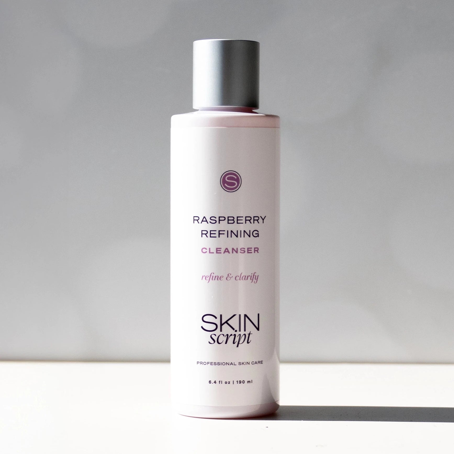Skincare bottle labeled 'Raspberry Refining Cleanser' by 'Skin Script' on a neutral background