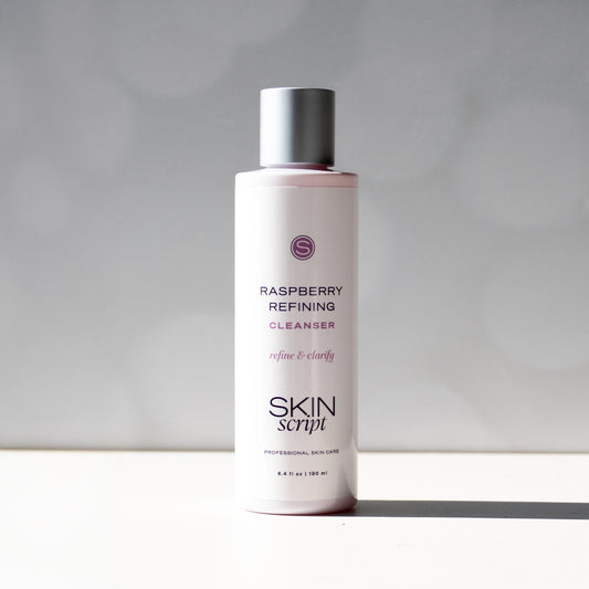 Skincare bottle labeled 'Raspberry Refining Cleanser' by 'Skin Script' on a neutral background