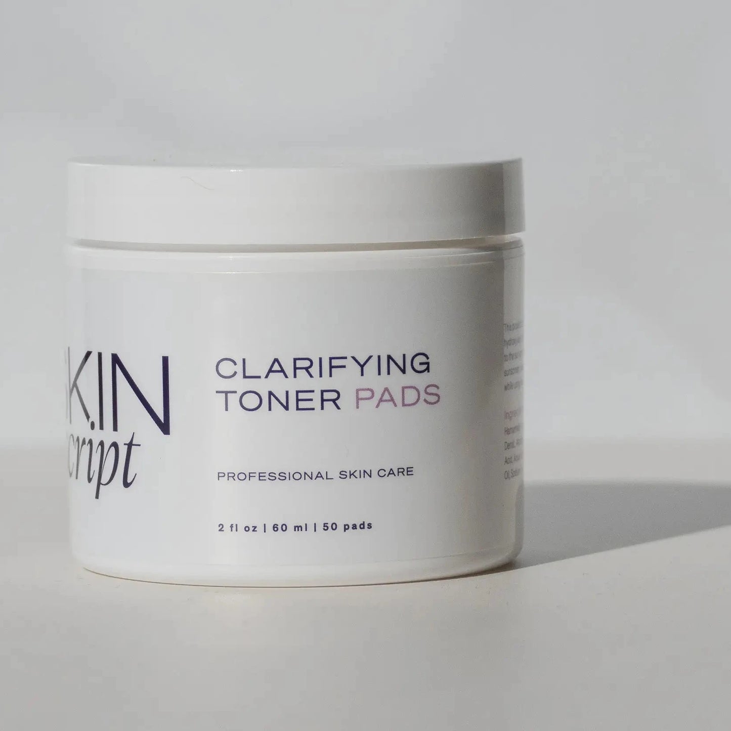 Skin script clarifying toner pads jar on a grey background