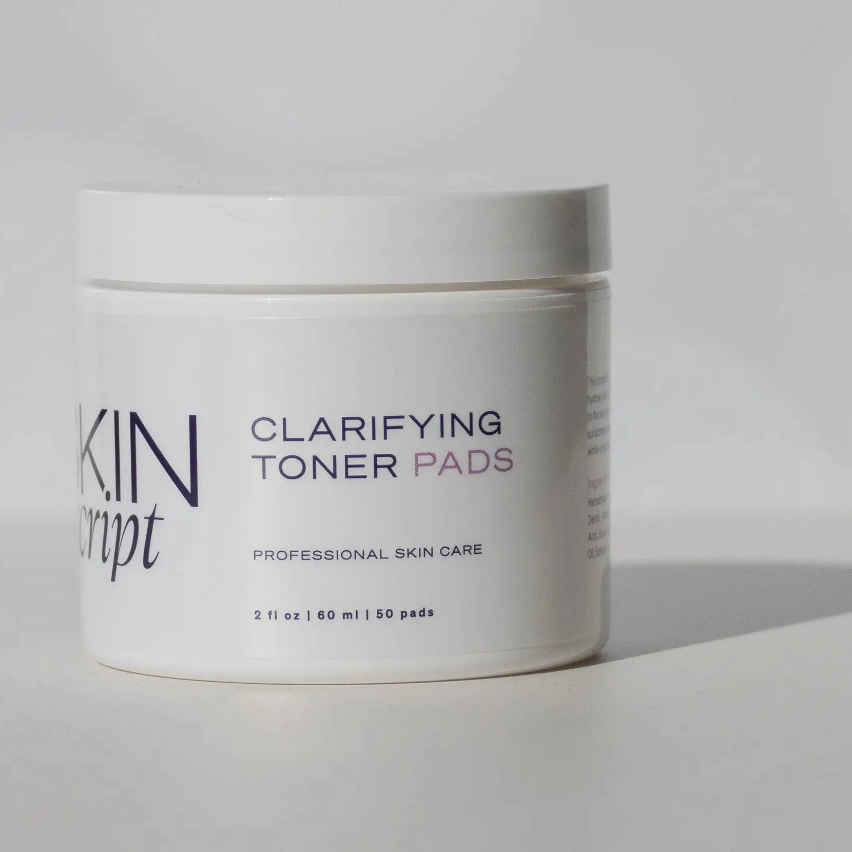Skin script clarifying toner pads jar on a grey background