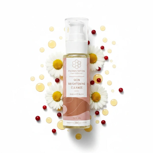 Rhonda Allison Skincare bottle labeled 'Skin Brightening Cleanse' with brand logo on a white background scatter of daisy flow and cranberry seed oil
